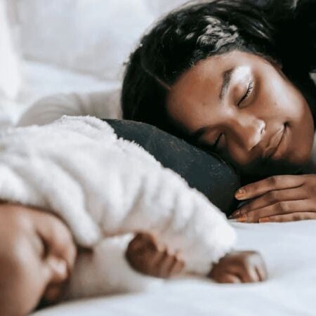 Toronto new mom sleeping with baby on bed